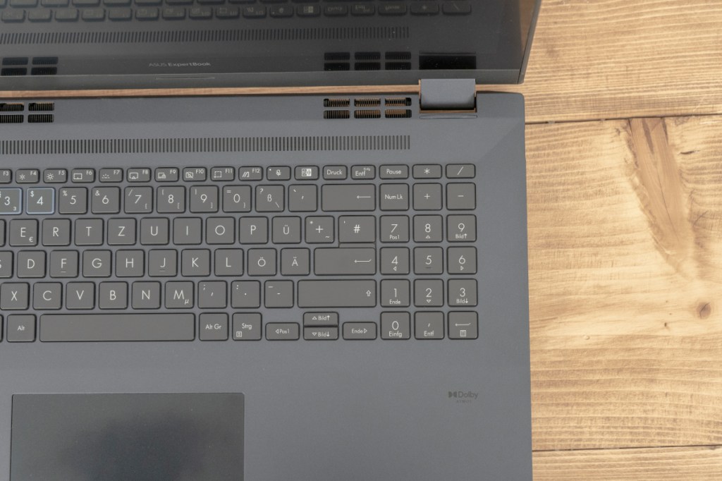 Detail graues aufgeklapptes Notebook Tastatur von oben auf hellem holz