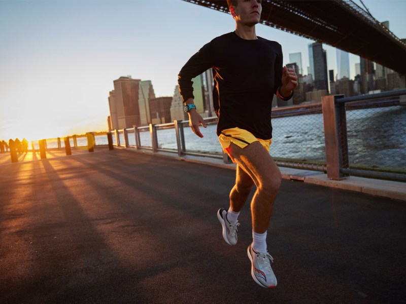 Ein Mann joggt am Fluss in New York und trägt eine Garmin.