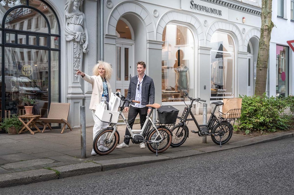zwei Personen neben ihren Kompakt-E-Bikes in der Stadt