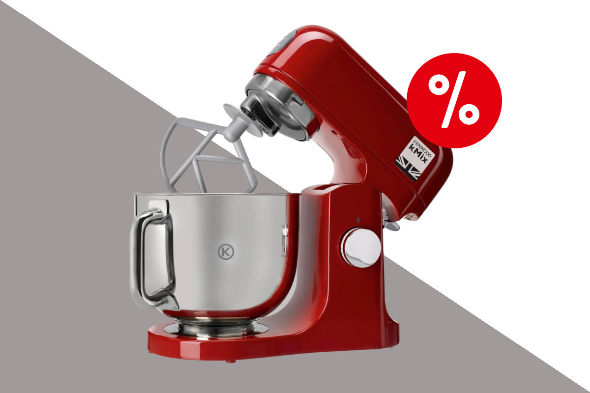 Rote Kenwood K-Mix Küchenmaschine mit Rührarm hochgeklappt und silbernem Topf darauf auf grau weißem Hintergrund mit rotem Prozentzeichen oben rechts