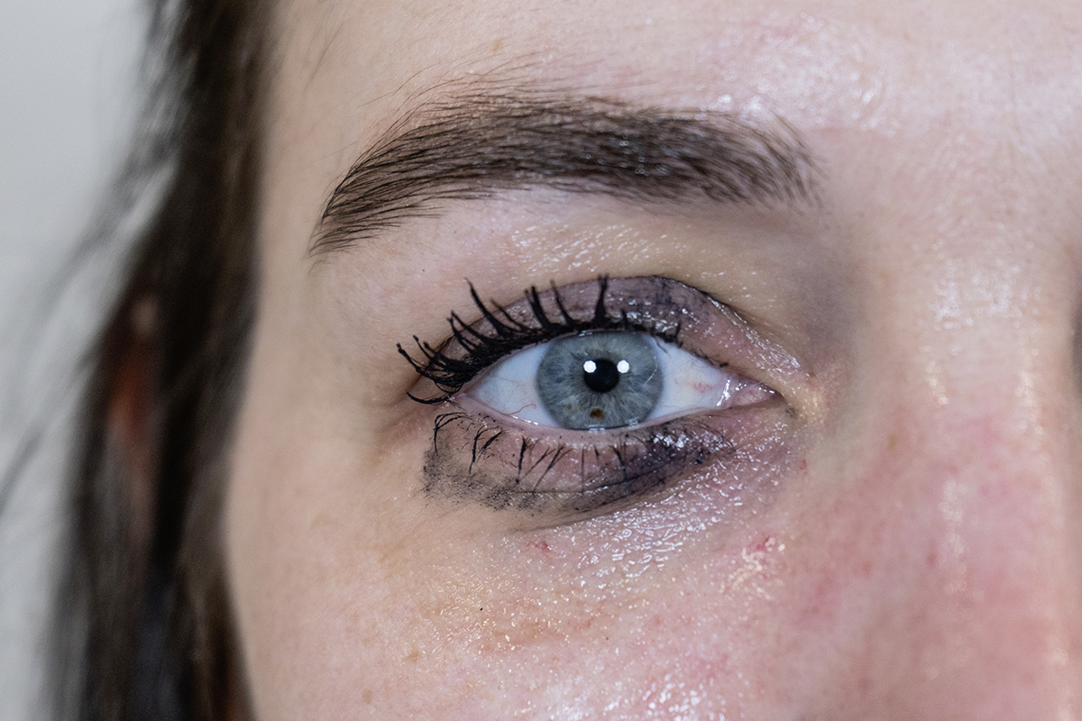 Blaues Auge von Frau mit verschmierter Mascara