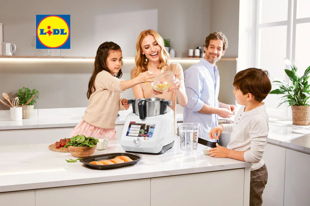 Eine vierköpfige Familie, ein Vater und eine Frau mit zwei Kindern die in der Küche mit dem Monsieur Cuisine hantieren.