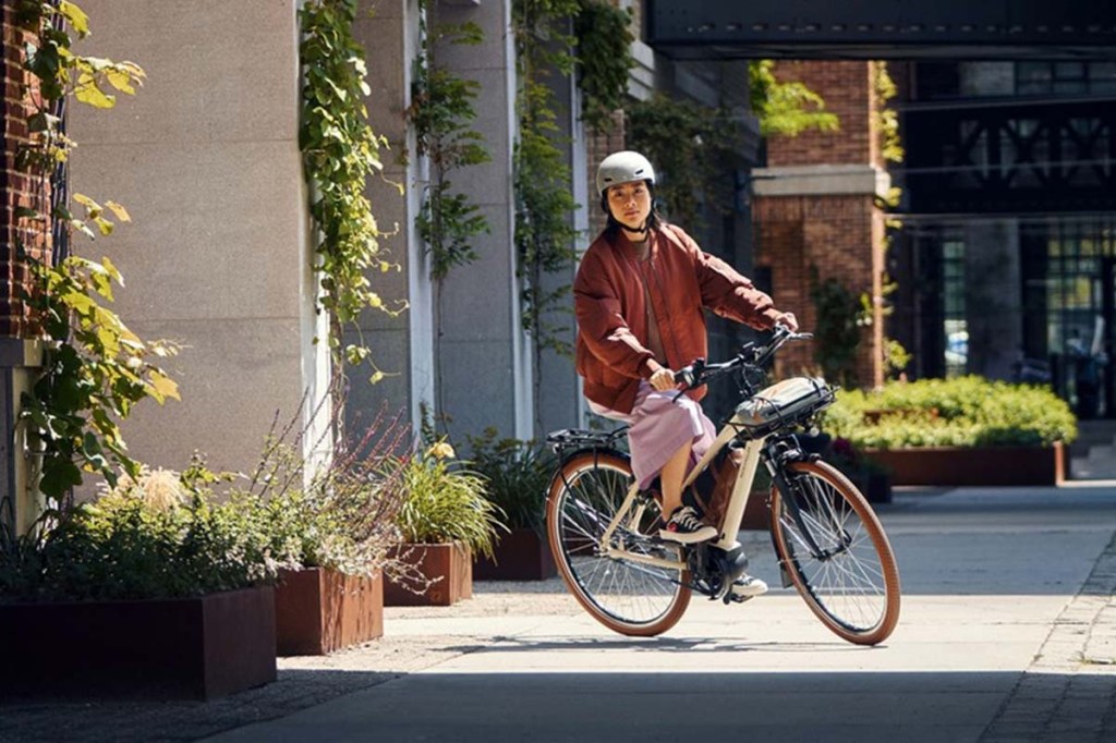 Frau fährt mit ihrem E-Bike durch die Stadt