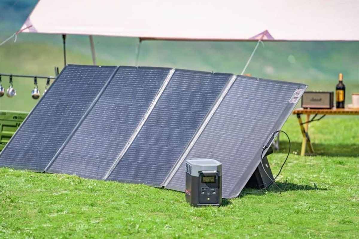 Eine Power Station steht auf einer grünen Wiese mit mobilem Solarmodul.