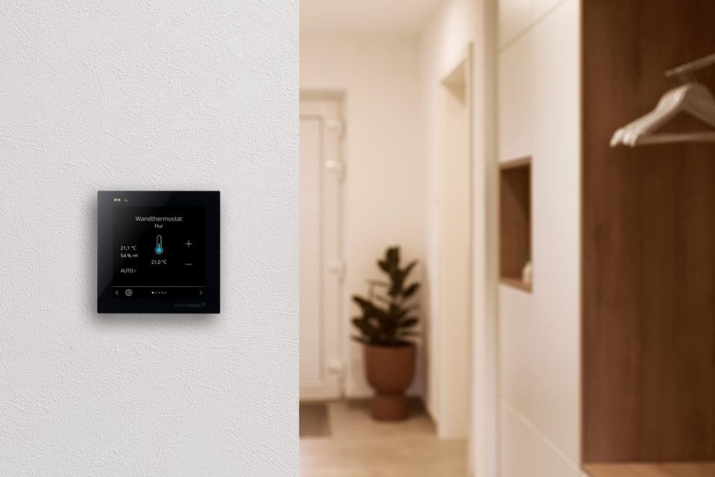 Ein Homematic IP Wired Glasdisplay - plus hängt an einer Wand im Flur und zeigt die Temperatur im Flur an.
