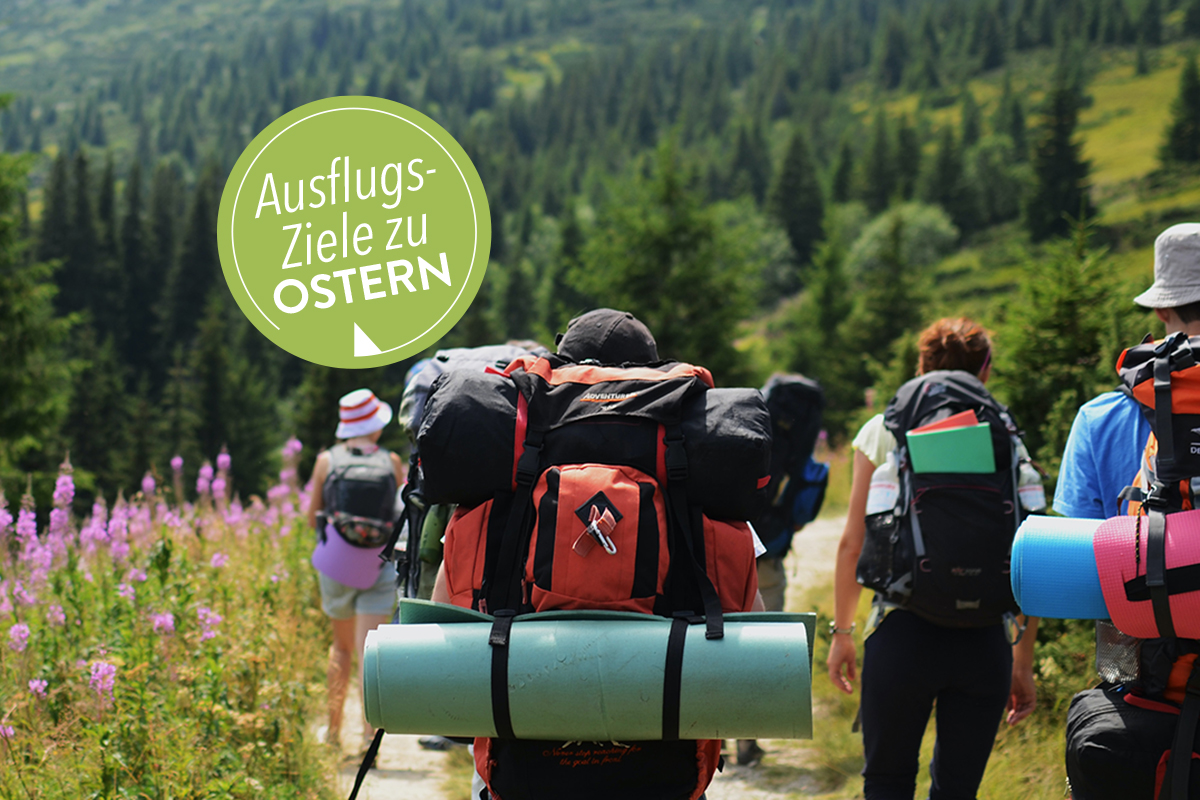 Gruppe von Menschen mit Rucksäcken wandern durch Berglandschaft; grüner Stempel "Ausflugsziele zu Ostern"
