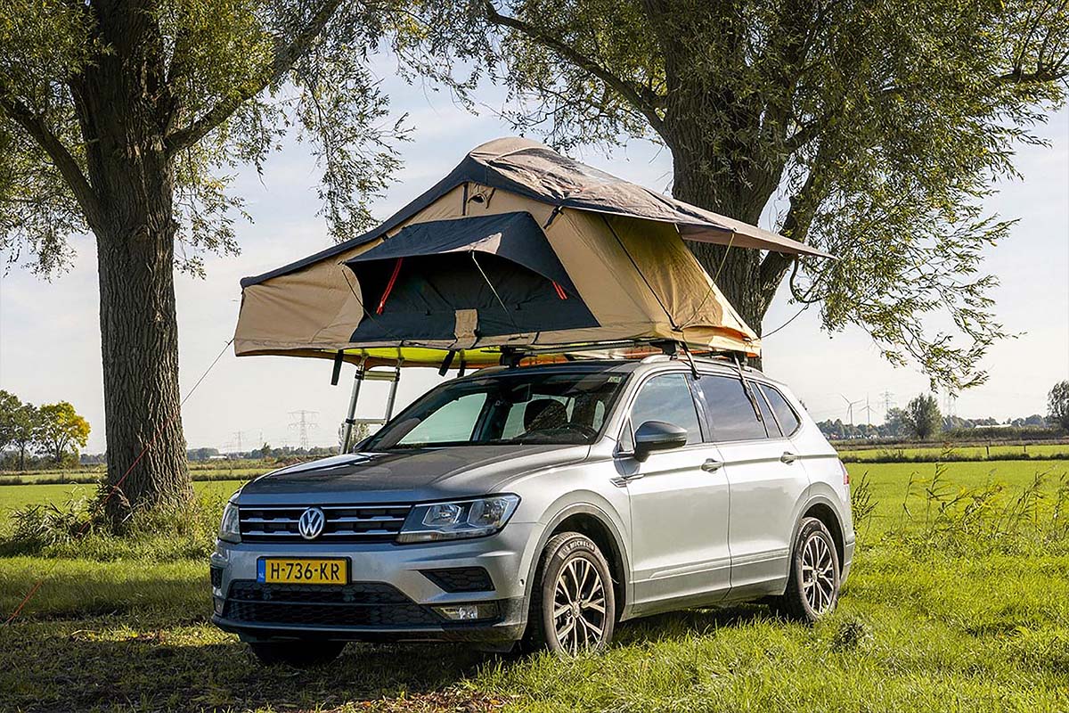 Auto mit Dachzelt auf einer Wiese stehend