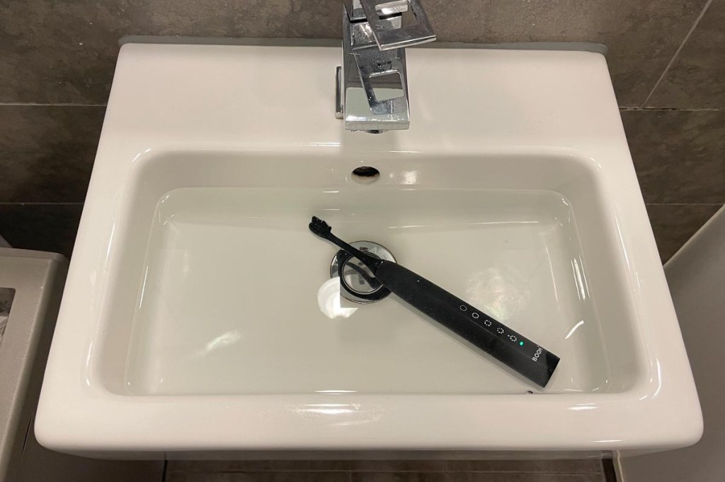 Eine E-Zahnbürste in einem mit Wasser gefüllten Waschbecken.