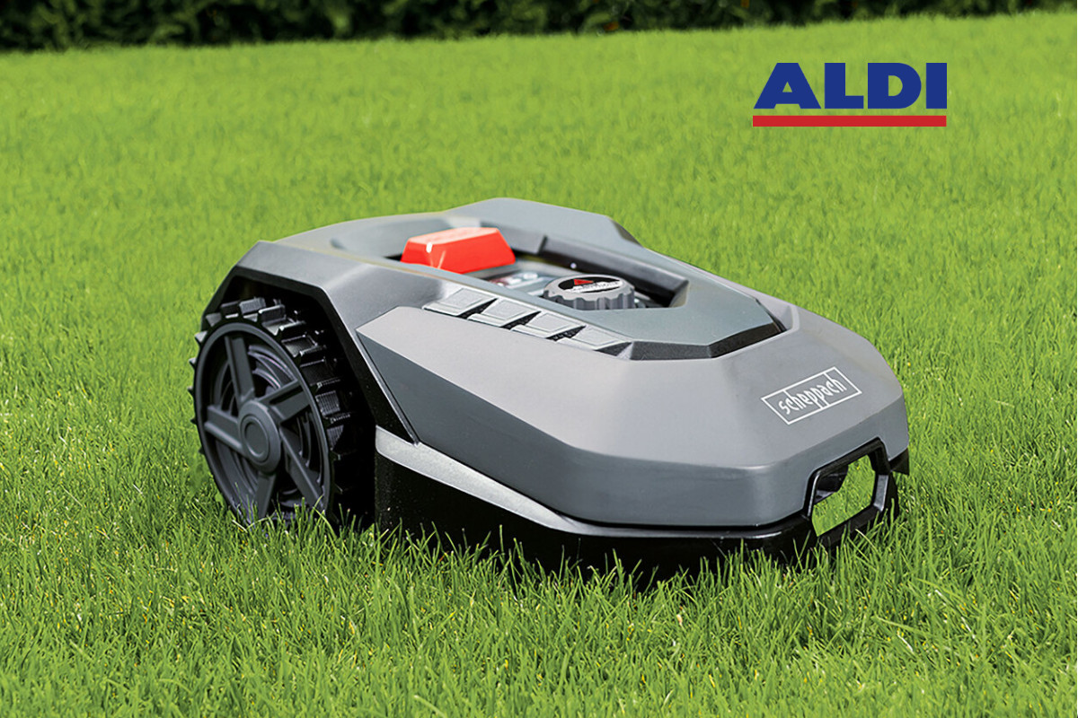 Grauer Scheppach-Mähroboter schräg von Vorne auf grünem Gras mit Aldi schriftzug oben rechts