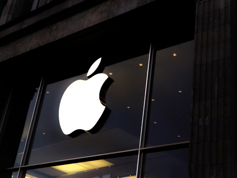 Das weiße Apple Logo vor dunklem Hintergrund.
