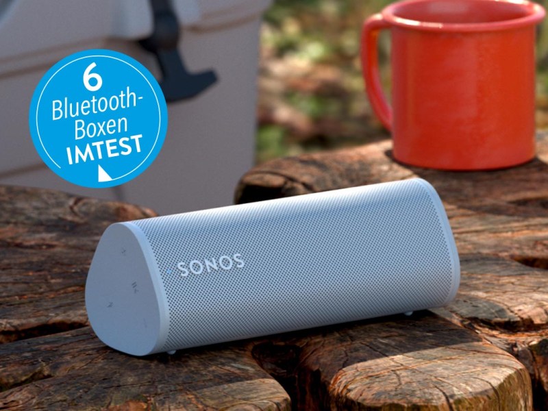 Bluetooth-Box von Sonos auf einem Baumstamm unter freiem Himmel.