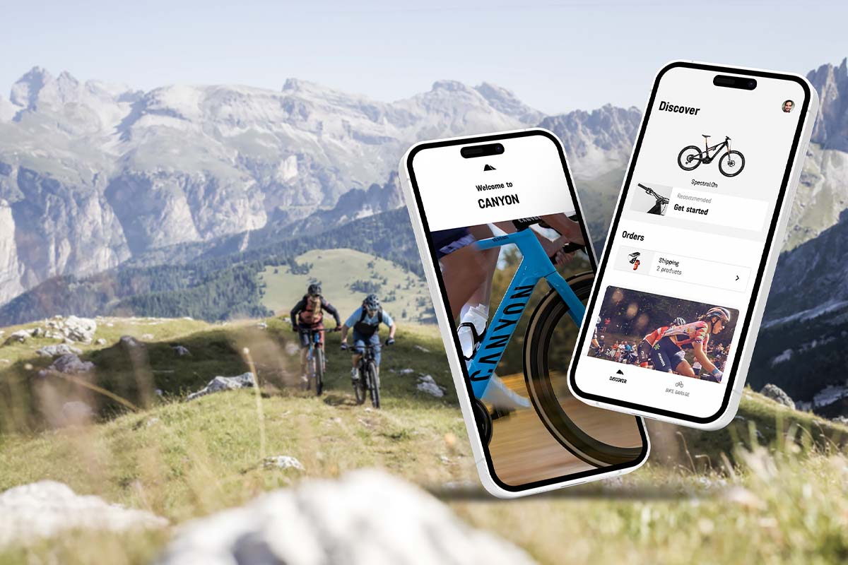 Zwei E-Bike Fahrer in den Bergen, im Vordergrund zwei Smartphonebildschirme