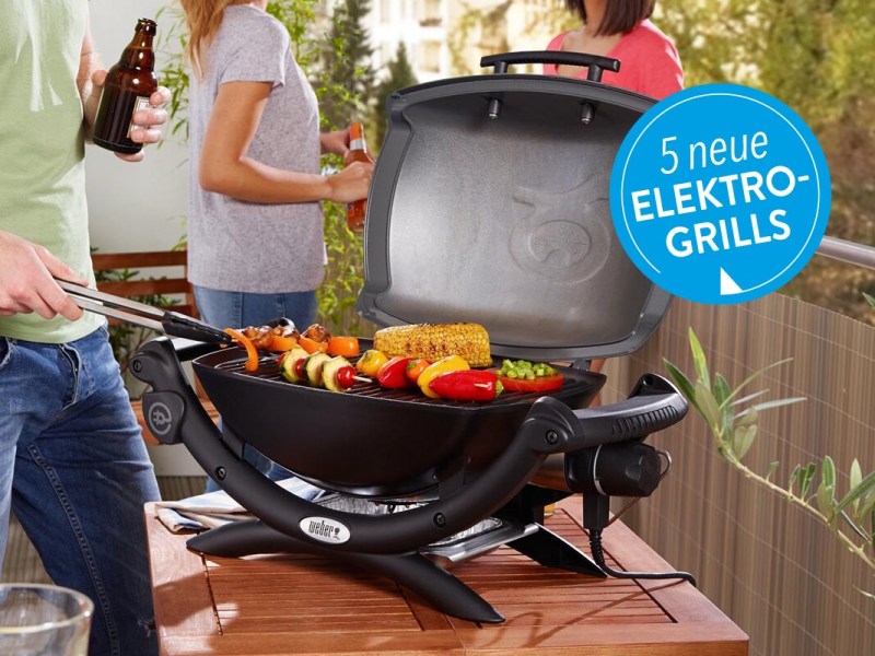 Ein Elektrogrill auf einem Holztisch unter freiem Himmel.