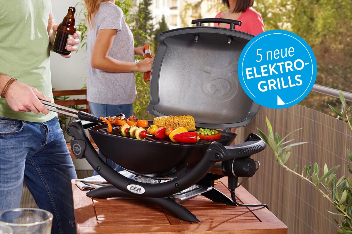 Ein Elektrogrill auf einem Holztisch unter freiem Himmel.
