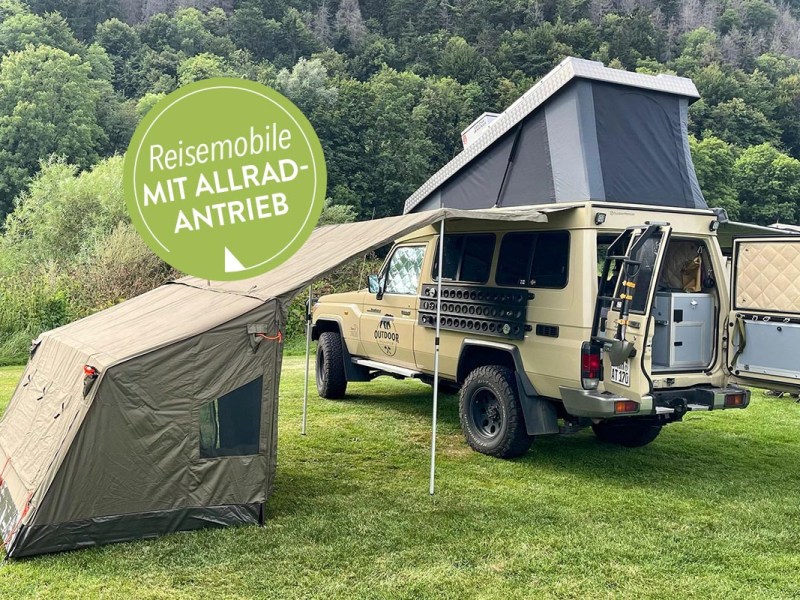 Wohnmobile für Abenteurer: Land Cruiser mit aufgestelltem Hochdach und Beistellzelt vor Waldlandschaft.