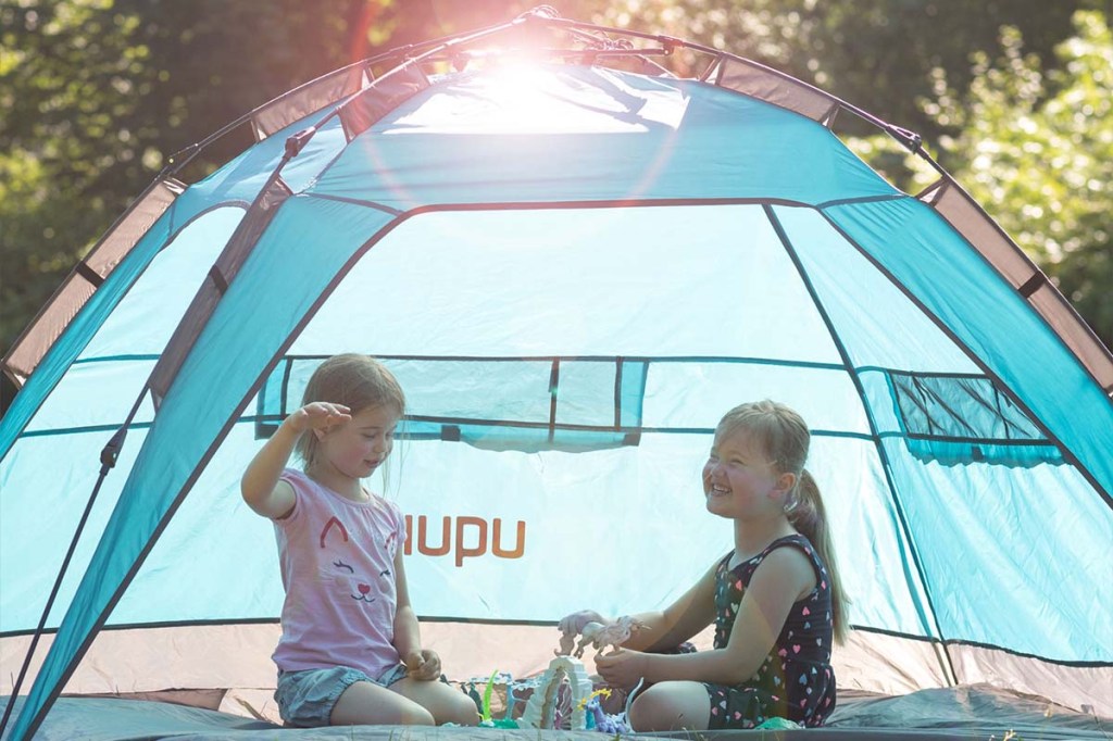 Türkise Strandmuschel, in der zwei Kinder sitzen