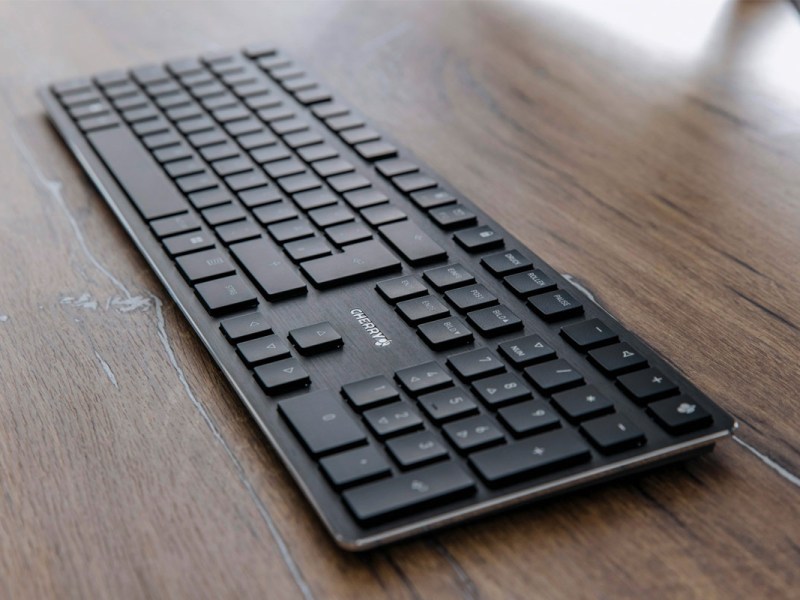 Die neue Cherry-Tastatur liegt auf einem Holztisch.
