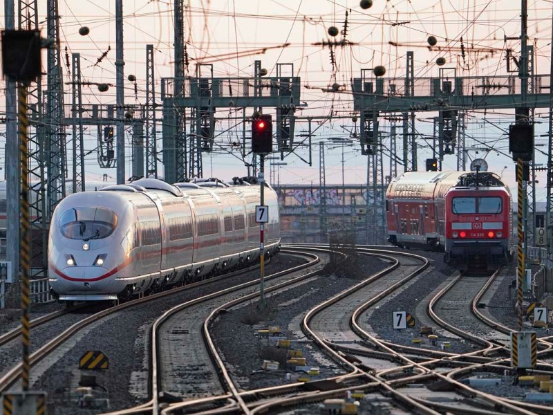 Züge stehen auf Gleisen in einem Bahnhof.