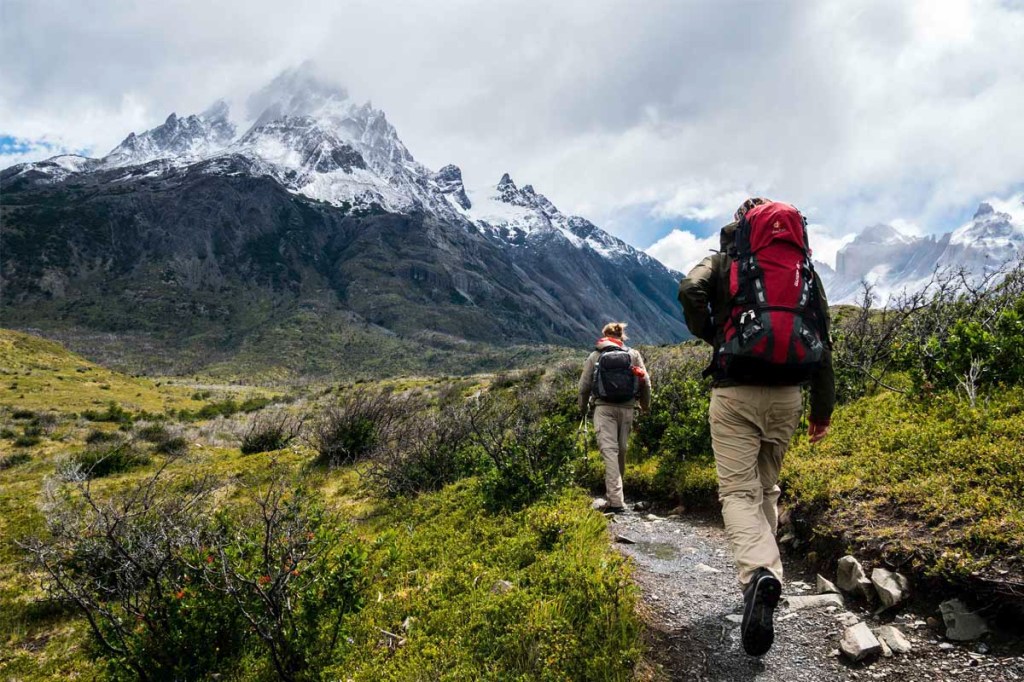 Zwei Menschen wandern durch eine bergige Landschaft.