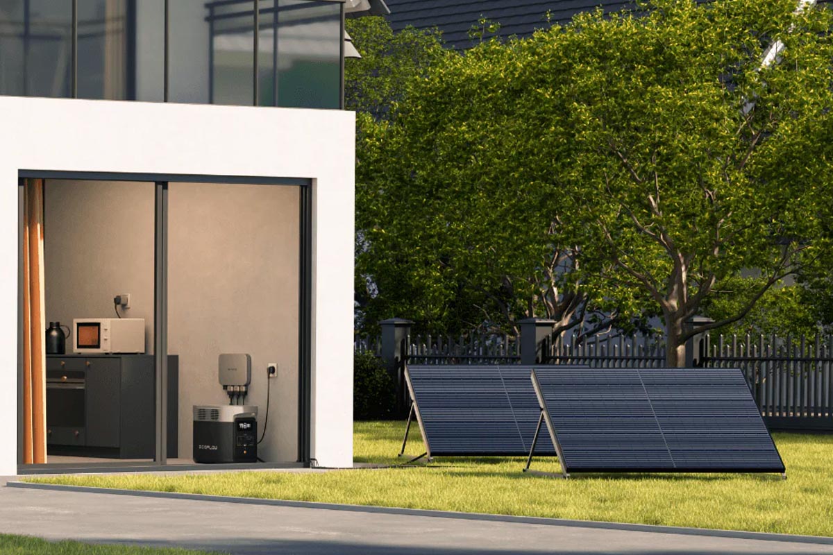 Ein Haus mit großer Terrasse und Solarpanels im Garten.