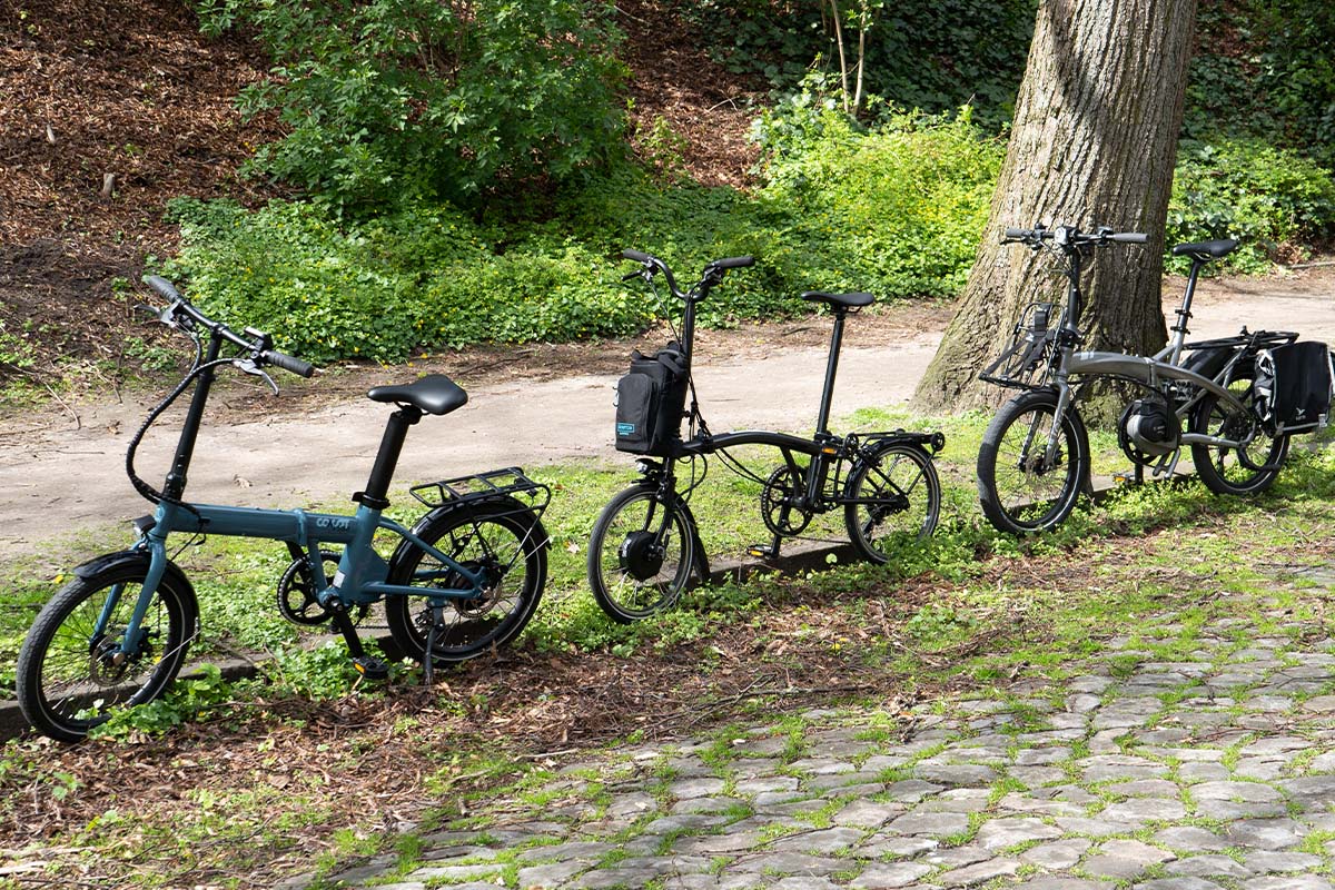 Drei Falt-E-Bikes stehen nebeneinander am Straßenrand