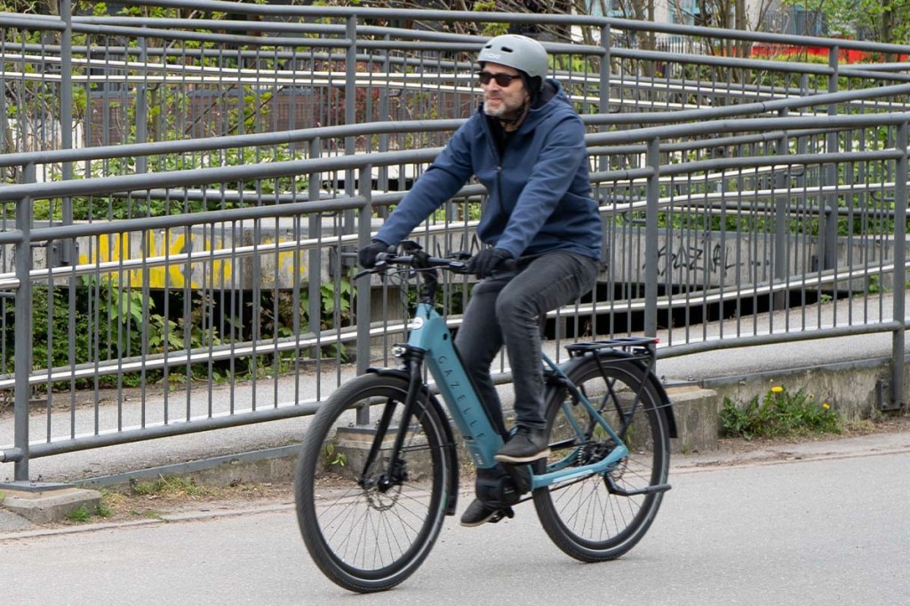 Mann fährt auf dem E-Bike Ultimate C5 von Gazelle über eine Straße