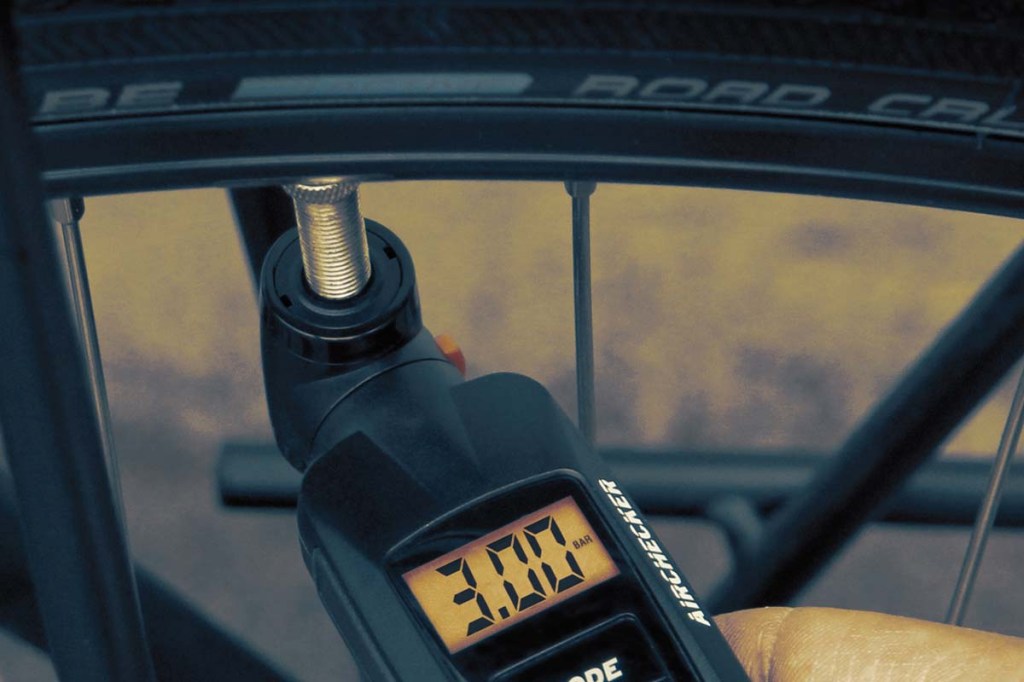 Nahaufnahme digitaler Luftdruckmesser am fahrradreifen