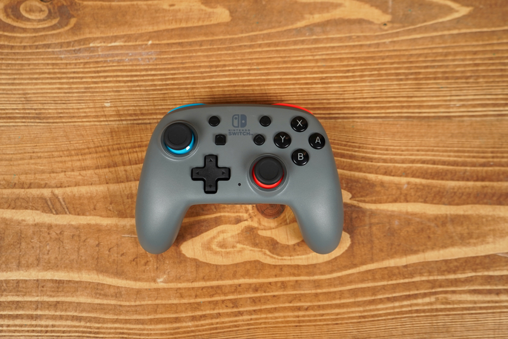 Ein Switch-Controller liegt auf einem Holztisch, direkt von oben fotografiert.