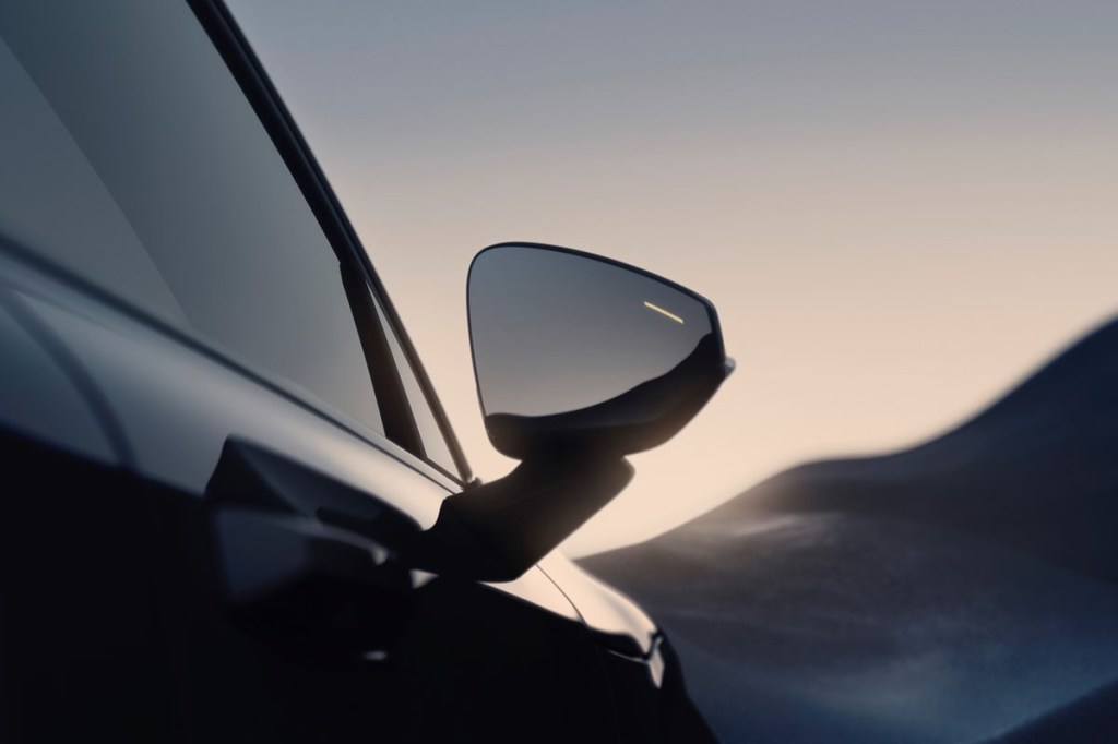 Detailaufnahme des Seitenspiegels beim E-Auto Volvo EX30 vor Sonnernuntergang.