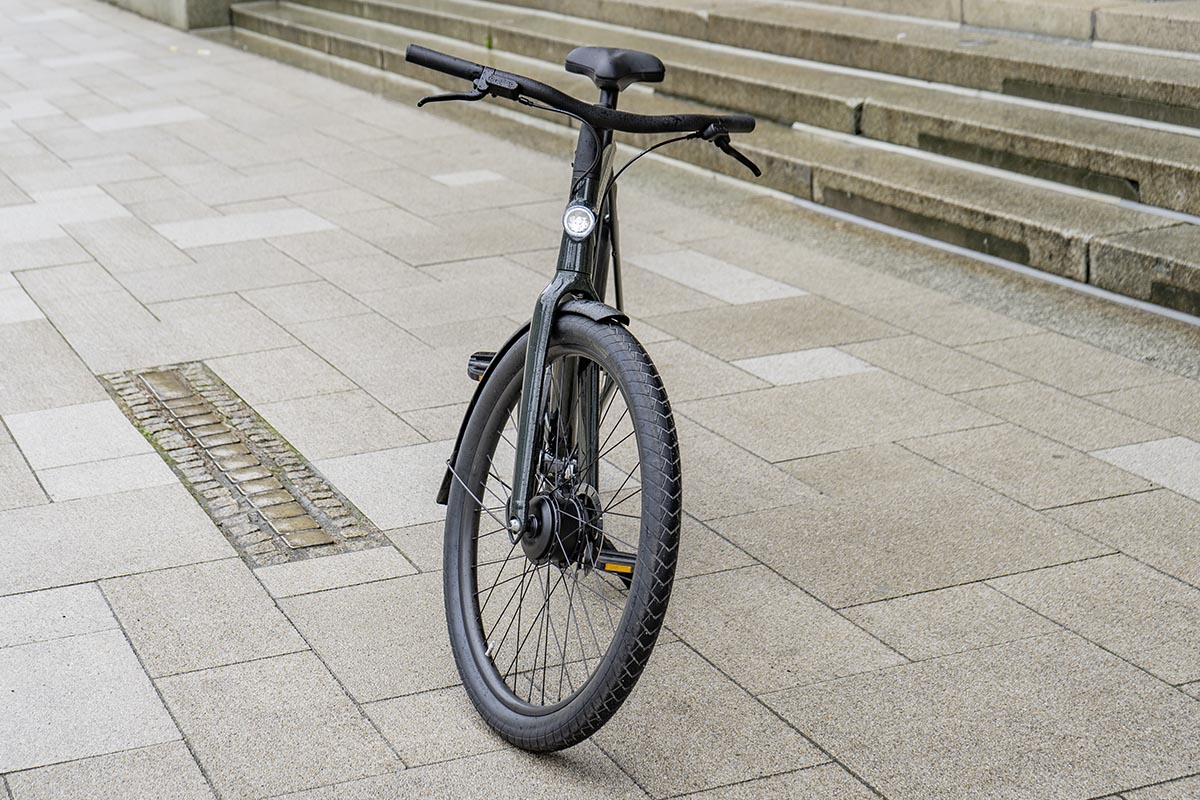 Frontansicht des City-E-Bikes VanMoof S4 vor Treppenstufen.