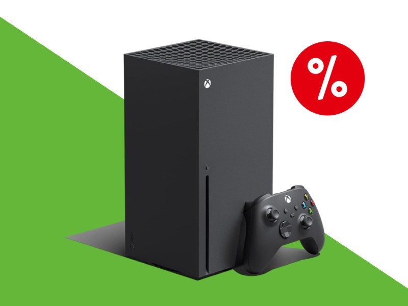 Schwarze eckige aufragende Xbox Series X schräg von vorne mit angelehnten schwarzen Controller rechts und rotem Prozentzeichen oben rechts auf weiß grünem Hintergrund