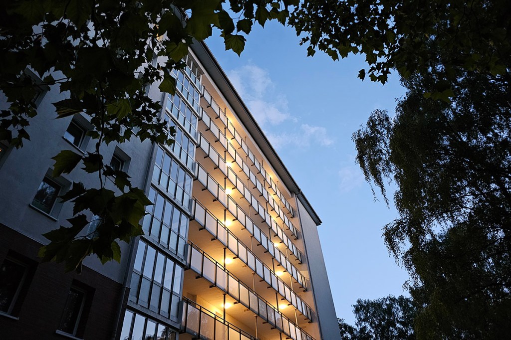 Nachtaufnahme einer Wohnungsfassade mit Beleuchtung in den EtagenGängen