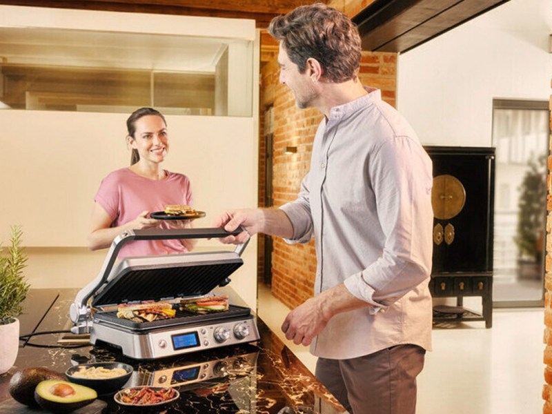 Ein Mann und eine Frau benutzen den Braun MultiGrill.