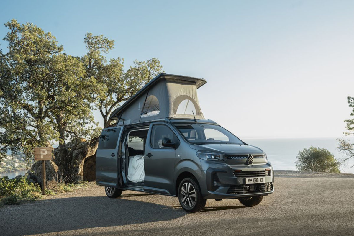 Camper Van-Alternative zum VW California: Ein Citroen Hoidays steht mit aufgestelltem Hochdach auf einem Parkplatz vor einem See.