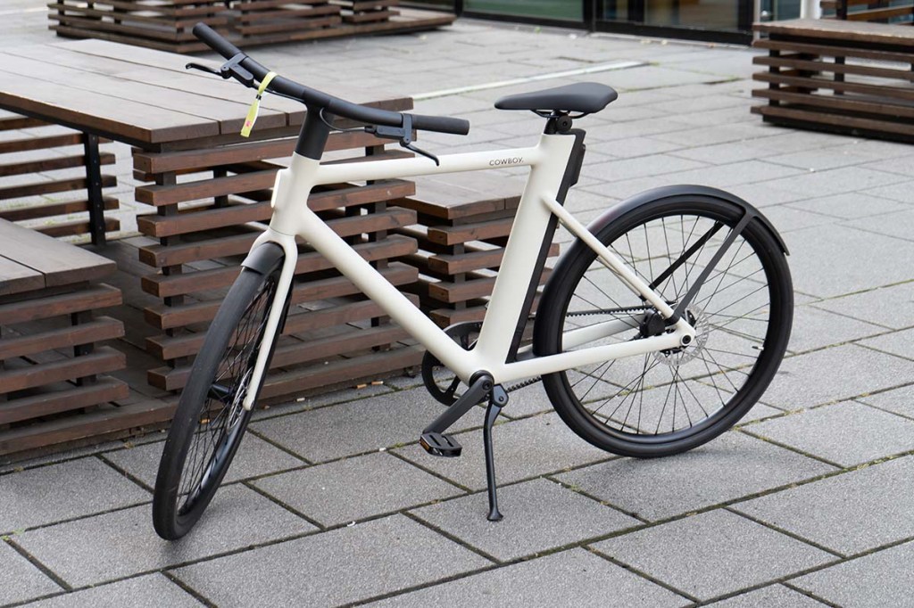 Totale E-Bike Cruiser von Cowboy vor einer Outdoor-Sitzbank stehend