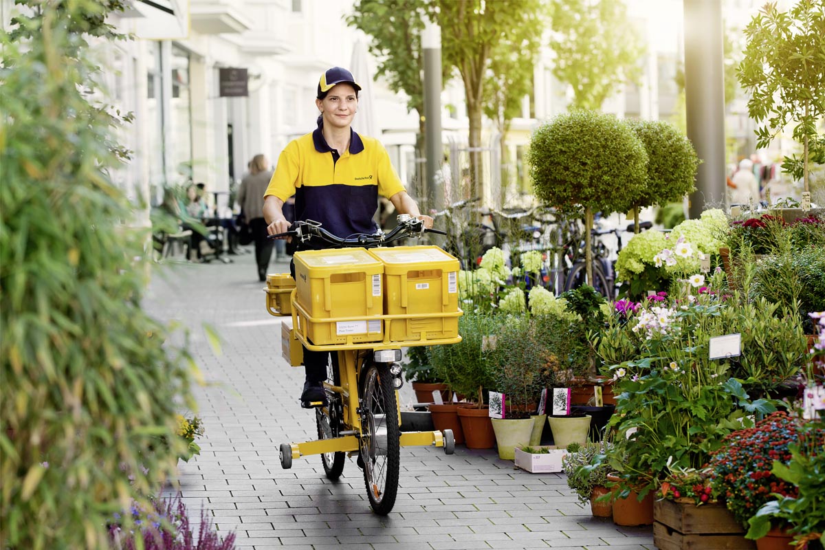 Briefzusteller bei der Zustellung auf einem Fahrrad.