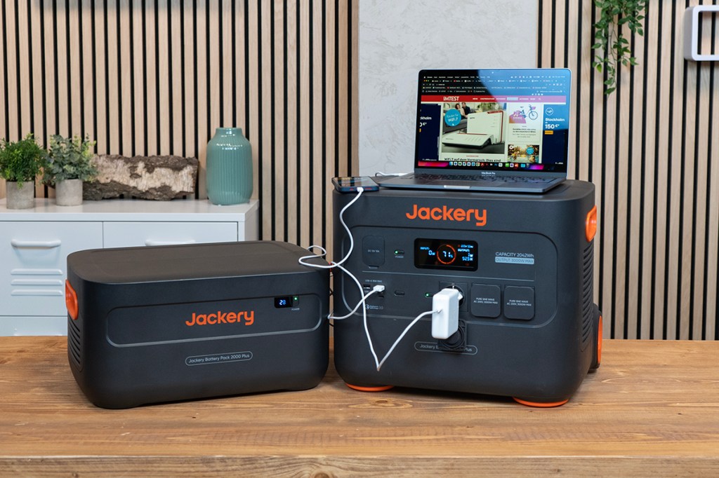 Die Jackery Explorer 2000 Plus mit Zusatzakku und angeschlossenem Notebook sowie Smartphone.