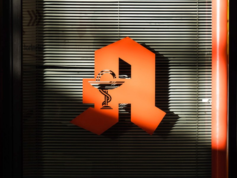 Ein Apothekensymbol vor einem verschlossenen Fenster.