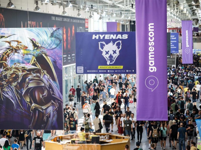 Ein Foto von der Gamescom, mit vielen Plakaten.