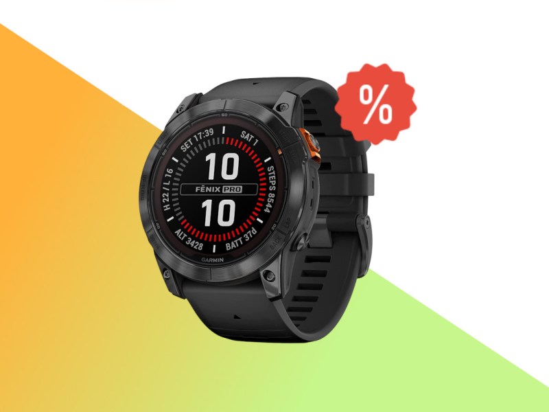 Schwarze Garmin Fenix 7 Pro Smartwatch schräg von vorne auf weißem Hintergrund mit orange grünem Farbverlauf unten und rotem Prozentzeichen rechts oben