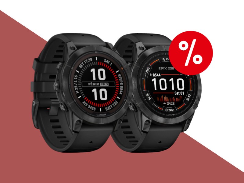 Zwei schwarze Garmin Smartwatches schräg von vorne nebeneinander auf dunkelrotem weißem Hintergrund mit rotem Prozentzeichen rechts oben