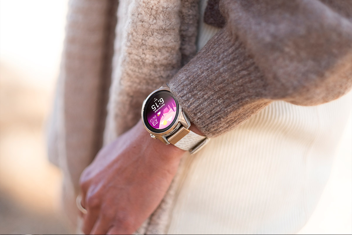 Eine Person mit Nicht-Sportkleidung trägt eine Garmin-Smartwatch mit beleuchtetem Display.