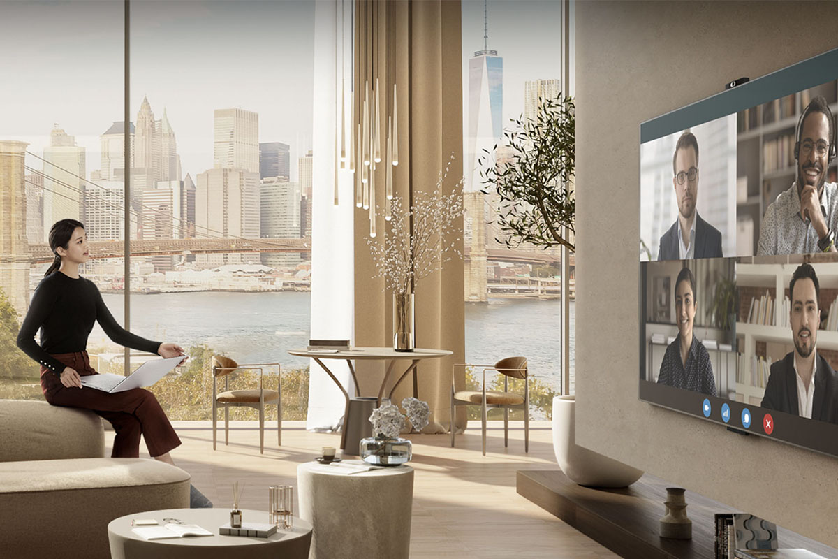 Eine Frau sitzt in einer stylischen Wohnung und führt eine Videokonferenz durch.