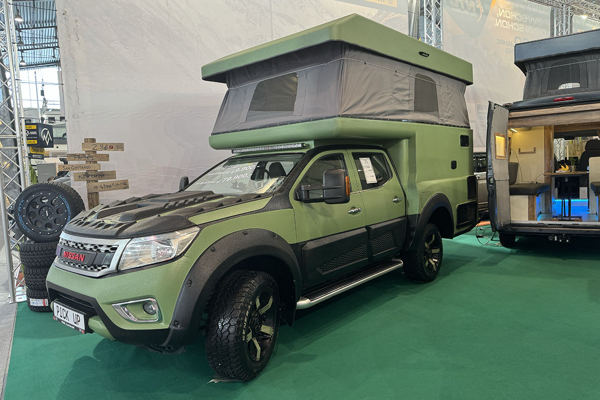 Nissan Pick-Up-Truck mit Camping-Kabine auf dem dem Heck und Hubdach.