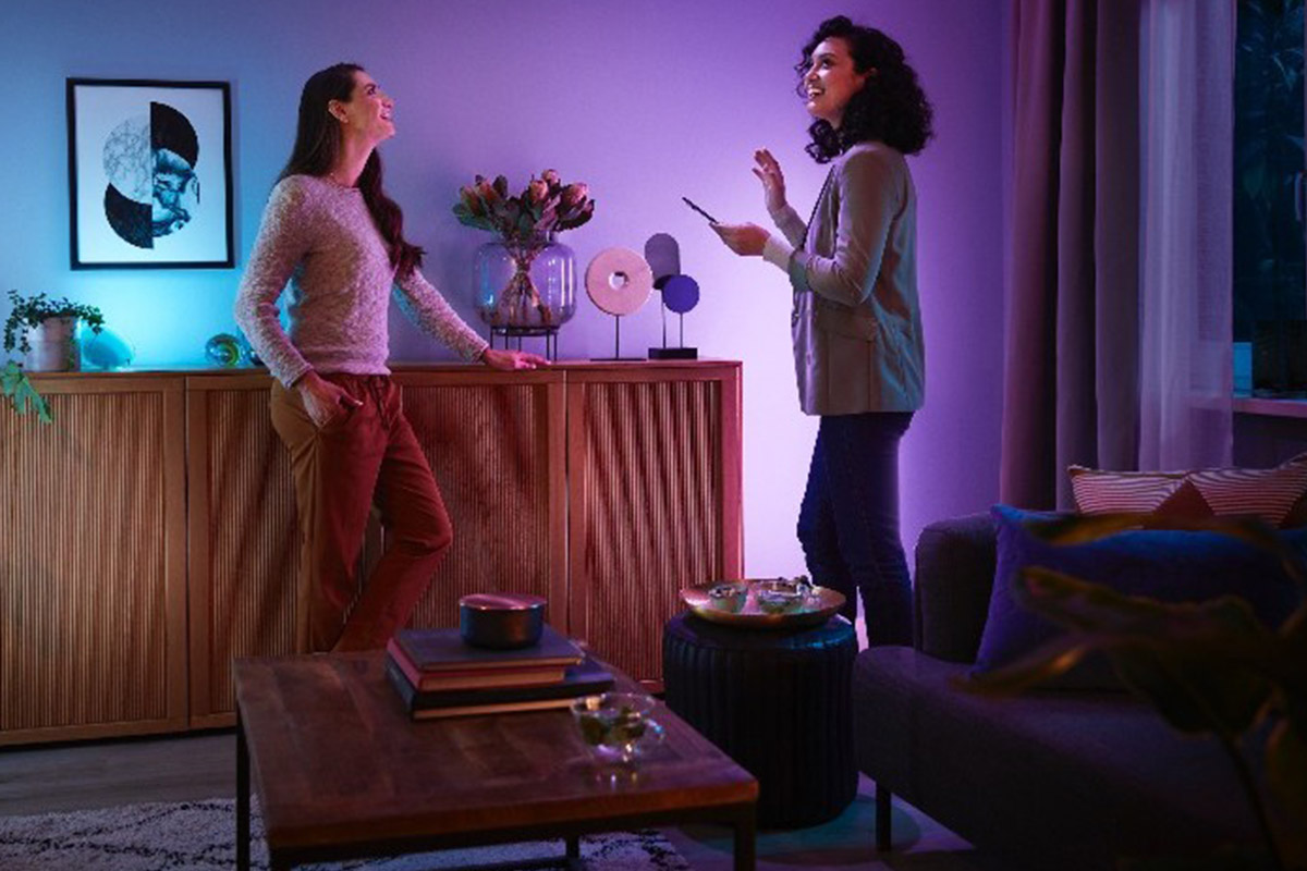Zwei Frauen stehen in einem Raum mit smarter Beleuchtung.