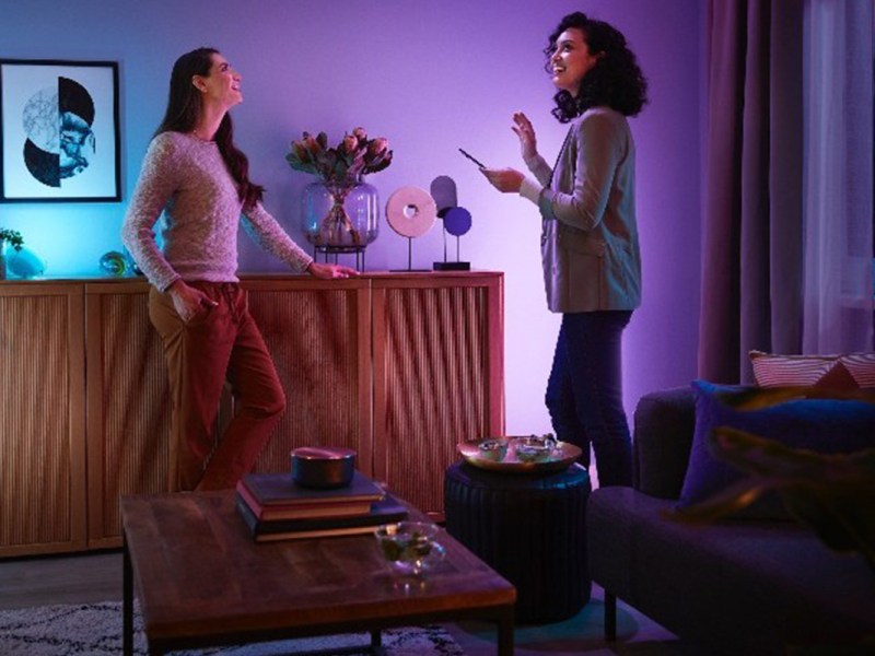 Zwei Frauen stehen in einem Raum mit smarter Beleuchtung.