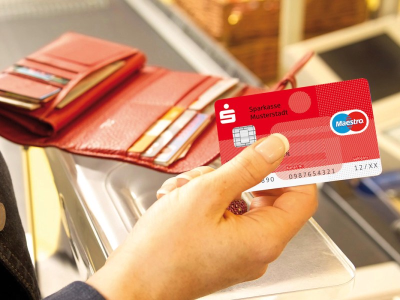 Eine Frau bezahlt mit einer Karte der Sparkasse.
