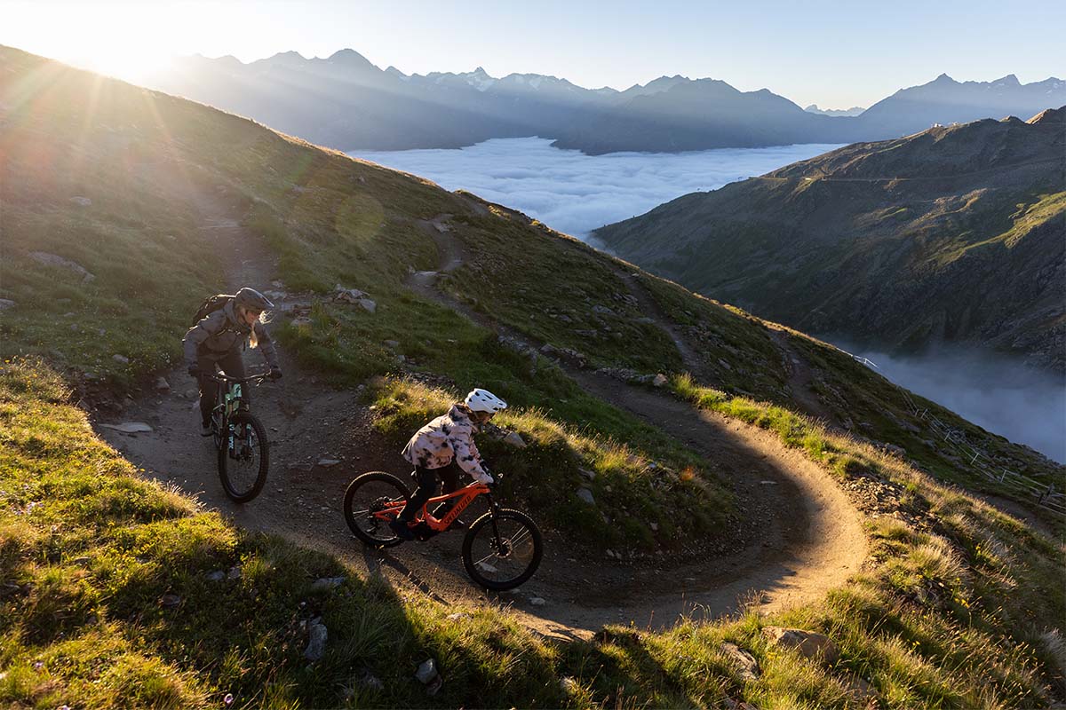 Kind fährt mit E-bike von Specialized einen Trail in einer Bergkulisse