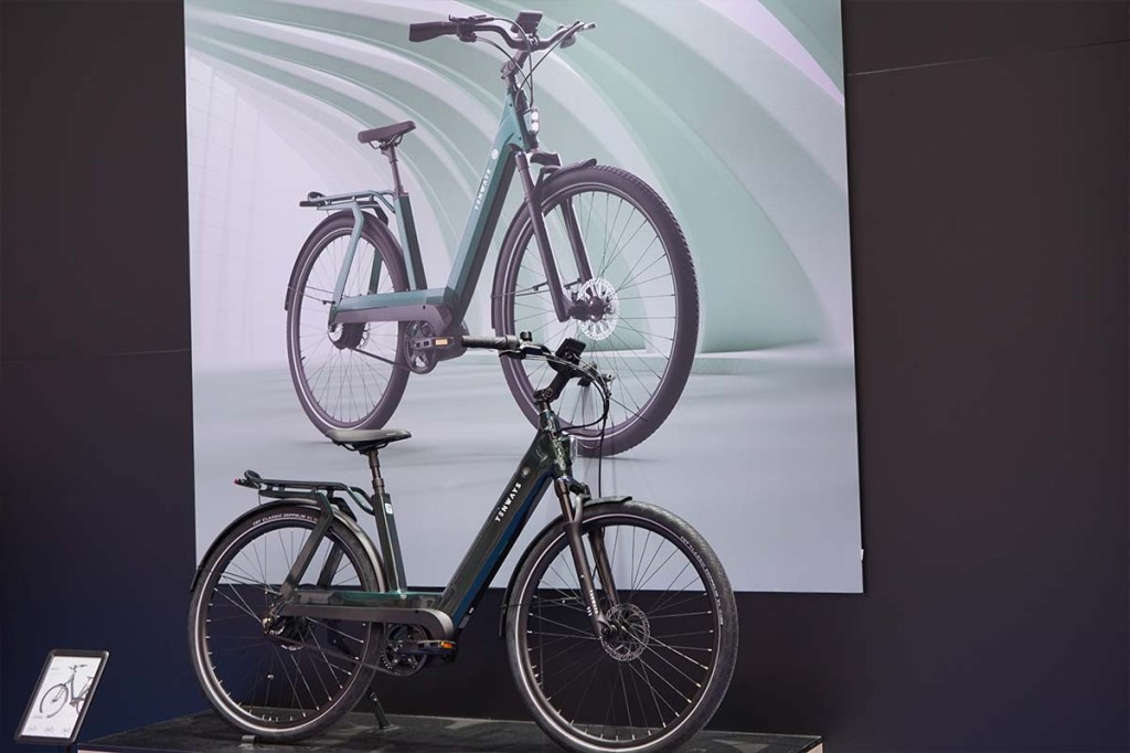 E-Bike von Tenways steht vor einer Wand, auf der das gleiche Rad als Foto abgebildet ist