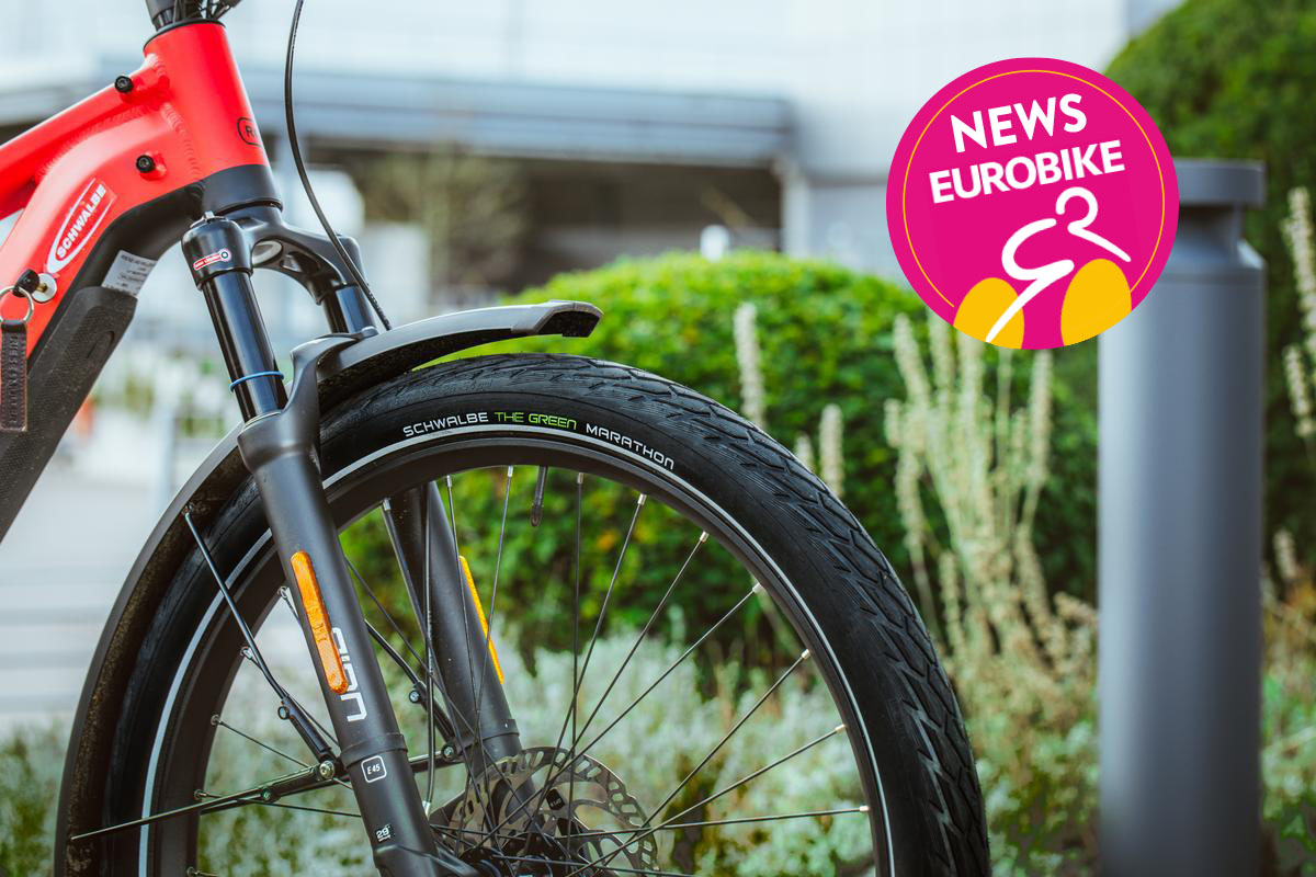 Detailaufnahme E-Bike-Reifen von Schwalbe an einem roten Rad vor unscharfem Hintergrund.